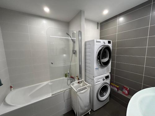 La salle de bains est pourvue d'un lave-linge et d'une baignoire. dans l'établissement Appartement 80 m2 Île de France Juvisy, à Juvisy-sur-Orge