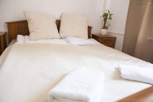 a white bed with white sheets and pillows at Szafran Home Spa in Korbielów