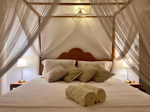 een slaapkamer met een groot bed met witte lakens en kussens bij Luxury Beach Condo Dehiwala Mt Lavinia in Watumulla