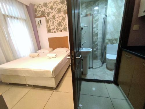 a bathroom with a bed and a shower and a toilet at Grafen House in Istanbul