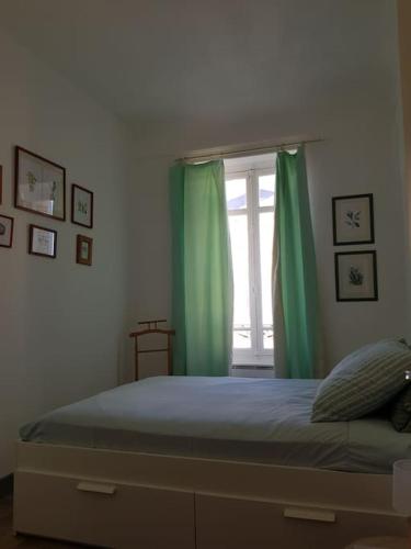 - une chambre avec un lit doté de rideaux verts et d'une fenêtre dans l'établissement Niort centre, bel appartement très nature, à Niort