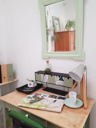 - un bureau avec un miroir et une lampe dans l'établissement Niort centre, bel appartement très nature, à Niort