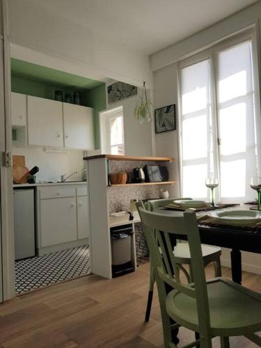 une cuisine avec une table et des chaises dans une pièce dans l'établissement Niort centre, bel appartement très nature, à Niort