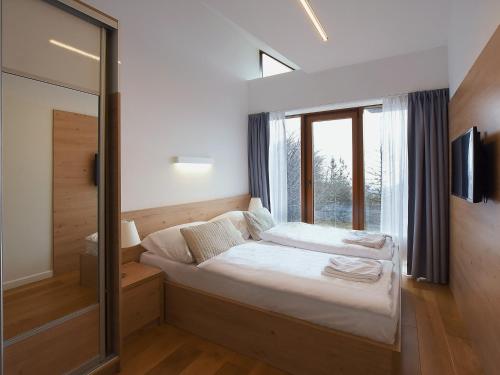 a small bedroom with a bed and a window at VacationClub - Górna Resorts Apartament 2.68 in Szklarska Poręba