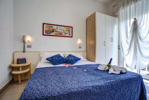 sypialnia z niebieskim łóżkiem i niebieskim kocem w obiekcie Hotel Tiziana w Rimini