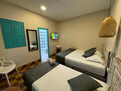 a bedroom with two beds and a table and a chair at CASA HOTEL LAS HORTENSIAS in Jardin