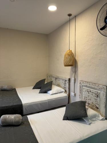 a bedroom with two beds and a pendant light at CASA HOTEL LAS HORTENSIAS in Jardin