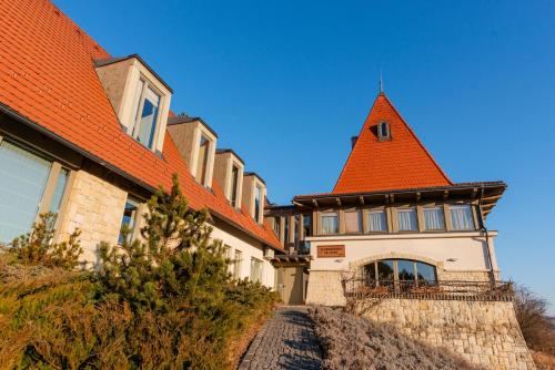 un edificio con techo naranja en una colina en Harmonia Mundi, en Vlaha