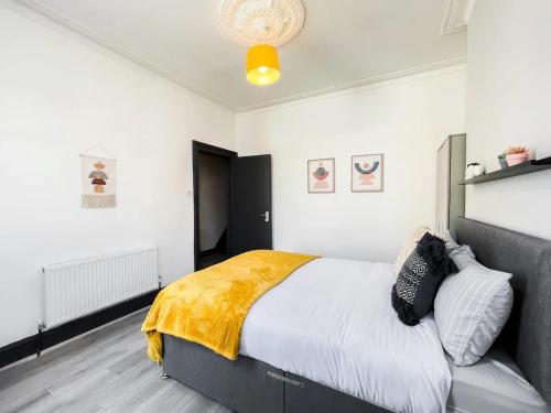 a bedroom with a bed with a yellow blanket on it at Superb House near Downtown Liverpool in Liverpool