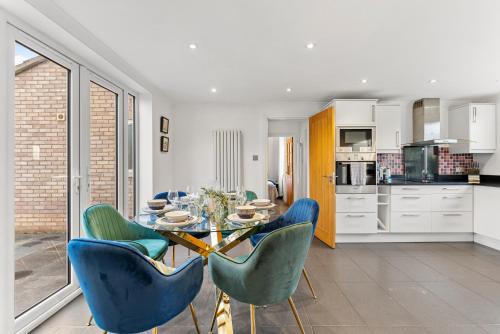 a dining room with a table and blue chairs at Unique Cambridgeshire Gem in Fulbourn