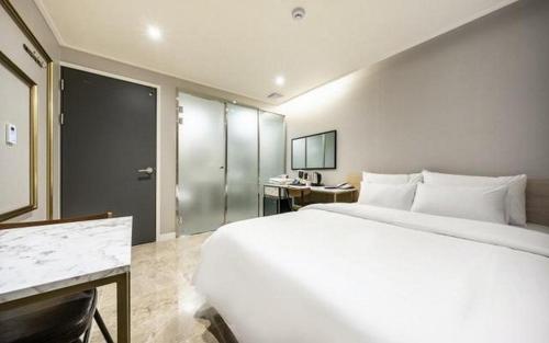 uma grande cama branca num quarto de hotel em Mnlucky Hotel em Seul