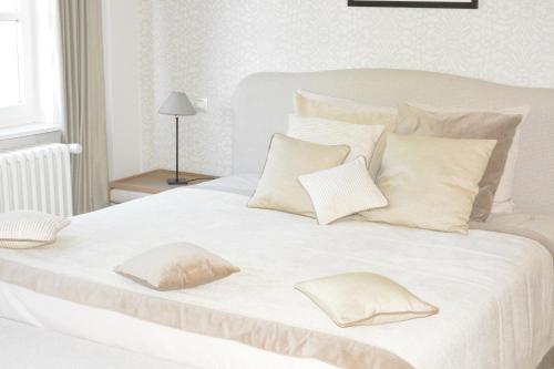 Cama blanca con sábanas y almohadas blancas en B & B Landhuis Ter Velt, en Melle