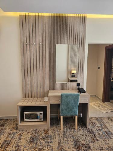 a desk with a mirror and a chair in a room at فندق سي قل - Sea gull Hotel in Umm Lujj