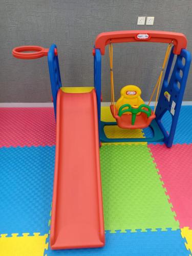 a playground with a slide in a room at Dorm Story For Hotel Apartment in Taif
