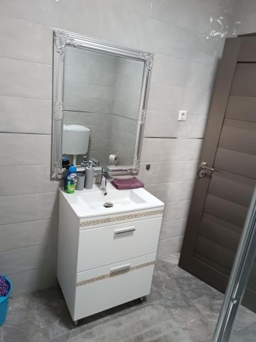 a bathroom with a white sink and a mirror at Mira apartman in Debrecen