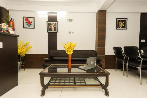 a room with a table with a laptop and chairs at Mirage Grand in McLeod Ganj