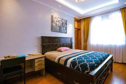 1 dormitorio con cama, escritorio y ventana en Cadenrockvilla - Furnished 3 bedroom villa with pool, en Ruiru