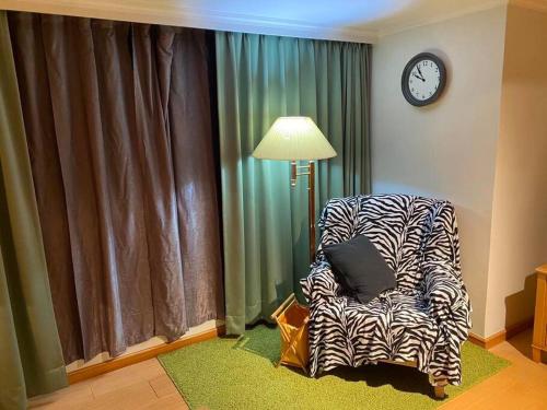 a zebra print chair in a living room with a clock at Large family room near Metro Taipei station for comfort and convenience, where 5 can relax and create unforgettable moments in Taipei