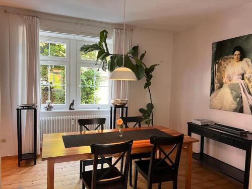 a dining room with a table and chairs and a piano at seeglueck SEELIEBE Stadtlage in Konstanz