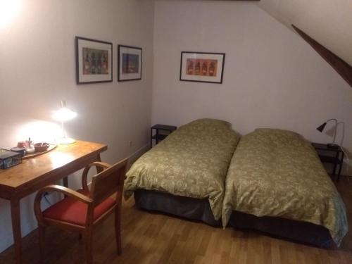 a bedroom with a bed and a desk and a desk at Chambre d'hôtes L'Ermite in Saint-Algis