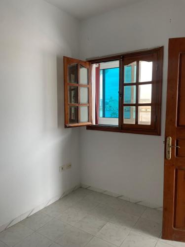 an empty room with a window and a door at Appartement spacieux, Résidence Les 5 étoiles, Bizerte in Zarzouna