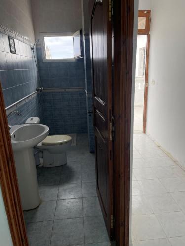 La salle de bains est pourvue d'un lavabo, de toilettes et d'une fenêtre. dans l'établissement Appartement spacieux, Résidence Les 5 étoiles, Bizerte, à Zarzouna