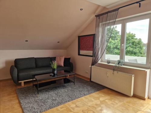 a living room with a couch and a large window at Komfortabel und Ideal für Frankfurt und Umgebung in Mörfelden-Walldorf