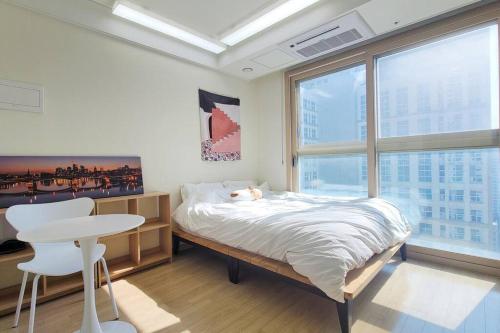 a bedroom with a bed and a table and a window at Oh~Misa! in Changnyemal