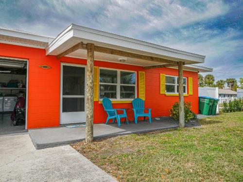 a orange house with two blue chairs in front of it at Sunny Delight I in Cape Canaveral