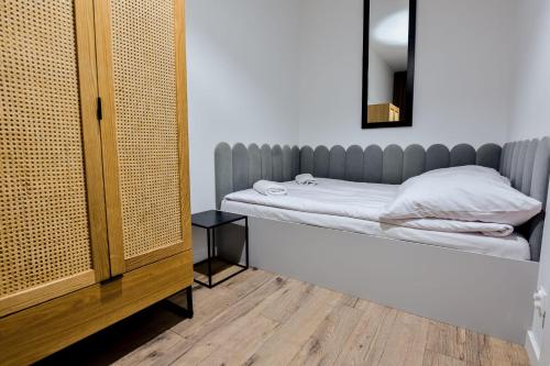 a bedroom with a bed and a mirror at VacationClub - Old Town Apartament 8B in Kłodzko