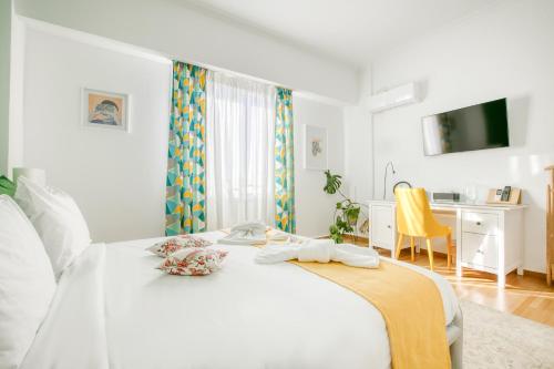 a white bedroom with a white bed and a desk at SMG Boutique Apartments in Athens