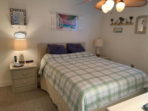 a bedroom with a bed with a plaid blanket at 405 Waters Edge in Myrtle Beach
