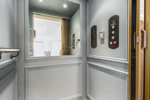 a bathroom with a door with a window and a remote control at The LUX at Craftsman - Heart of Old Town Studio 3 in Scottsdale