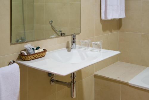 a bathroom with a white sink and a mirror at Hotel Pazo O Rial in Vilagarcia de Arousa