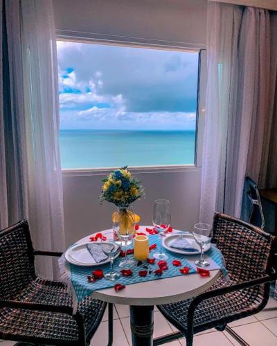 una mesa con vistas al océano desde una ventana en Milor hotel, en Natal
