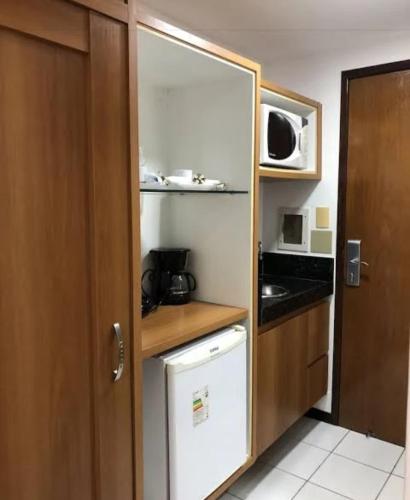 una pequeña cocina con fregadero y microondas en Milor hotel, en Natal
