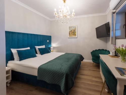 a bedroom with a large bed and a chandelier at Kanclerz in Zamość