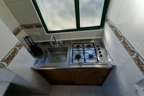 een kleine keuken met een wastafel en een fornuis bij Luminoso y confortable apartamento a 6 min aeropuerto in Bogota