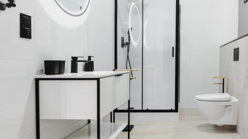 クウォツコにあるVacationClub - Old Town Apartament 15の洗面台とトイレを備えた白いバスルーム