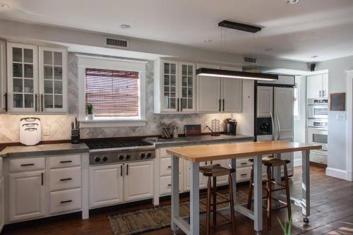 a kitchen with white cabinets and a wooden table at Roof Terrace Oasis in Savannah