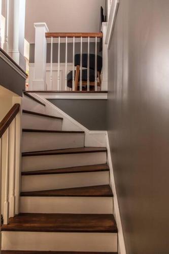 a staircase in a house with white stairs and a chair at Roof Terrace Oasis in Savannah