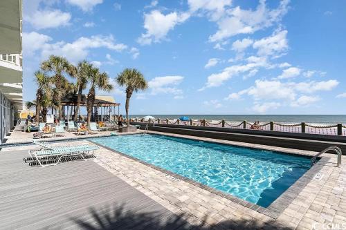 a swimming pool with the beach in the background at 405 Waters Edge in Myrtle Beach