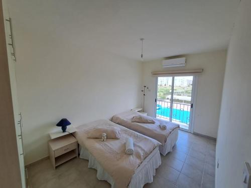 two beds in a room with a large window at Sapphire L44 in Iskele