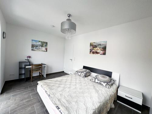 a white bedroom with a bed and a desk at Appartement Neugasse de Luxe - Komfort & Stil inklusive in Bad Camberg