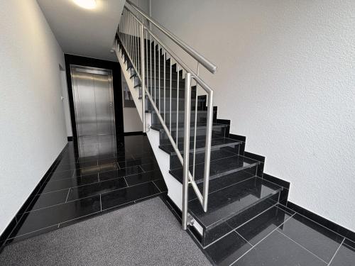 a black staircase with a metal railing in a building at Appartement Neugasse de Luxe - Komfort & Stil inklusive in Bad Camberg