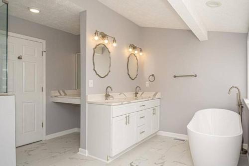 a white bathroom with two sinks and a tub at Historic Haymount House with Tuscan Vibe in Fayetteville