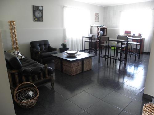 a living room with couches and a table and chairs at Alice´s House in Horta