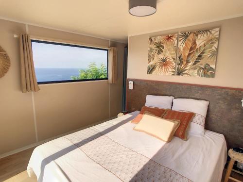 - une chambre avec un lit et une grande fenêtre dans l'établissement Kabane Bohème à St-Raphael au Cap Estérel, à Saint-Raphaël