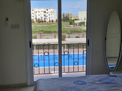 a bedroom with a view of a swimming pool through a window at Sapphire L44 in Iskele