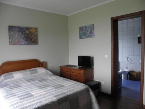 1 dormitorio con 1 cama y baño con lavamanos en Alice´s House en Horta